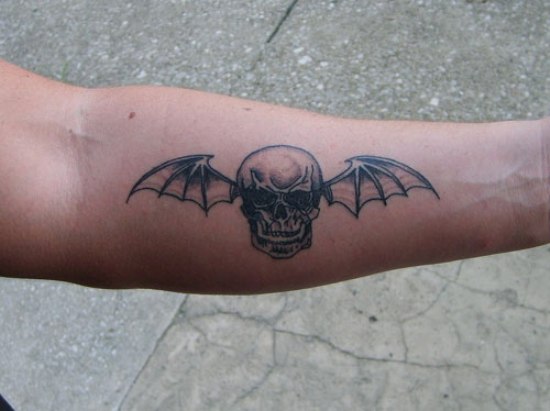 Egyszerű koponya szárnyas alkar tetoválással