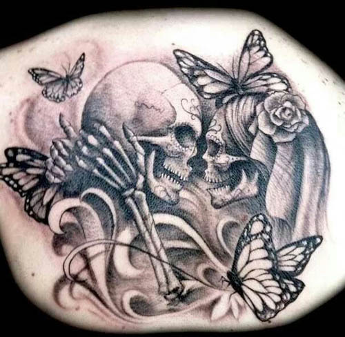 Kranium par tatovering med sommerfugle på ryggen