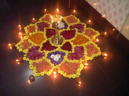 Rangoli designs med blomster og brændende diyas
