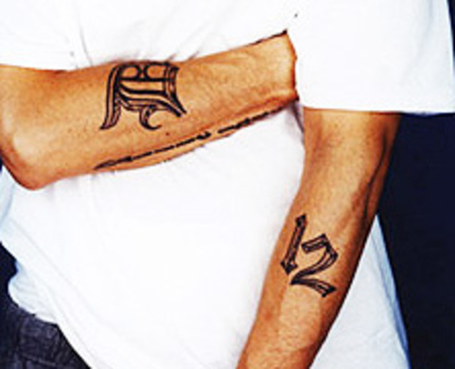 Eminem D Font Tattoo på højre arm