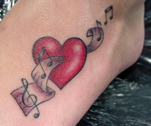 Piros szívzenei tetoválás női lábhoz