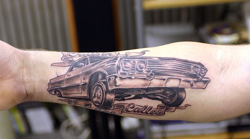 Gamle tatoveringsdesign på bilen på armen
