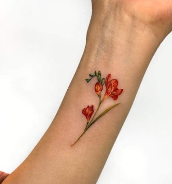 Charmerende Freesia Tattoo Design på håndleddet