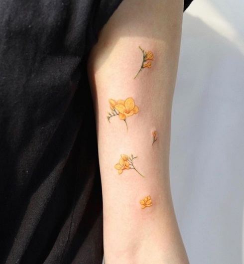 Gul Freesia -tatovering på armen
