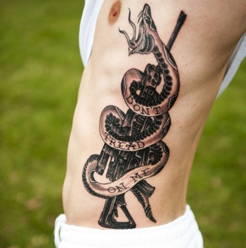 Pisztoly és kígyó tetoválás a férfiak oldalán