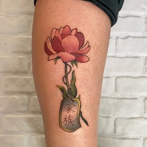 Pæon tatovering med et navneskilt