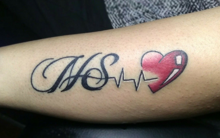 To bogstaver tatovering med hjerte og hjerteslag