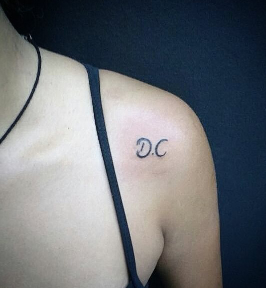 D és C tetoválás a vállán