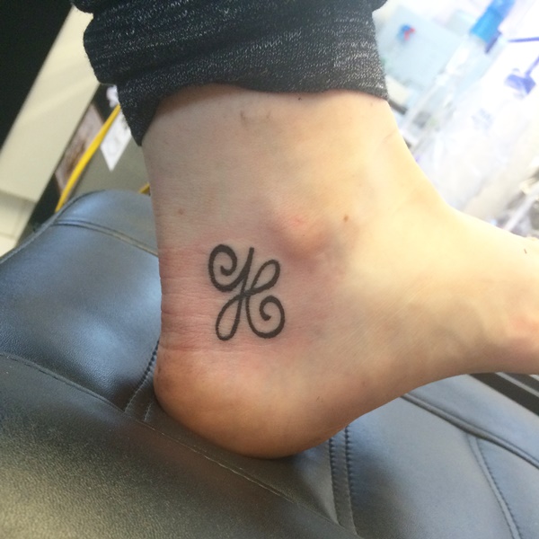 Aranyos H betűs tetoválás a bokán