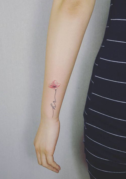 H betűs tetoválás egy gyönyörű rózsaszín virággal