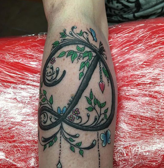 Kidolgozott D betűs tetoválás a természethez igazítva