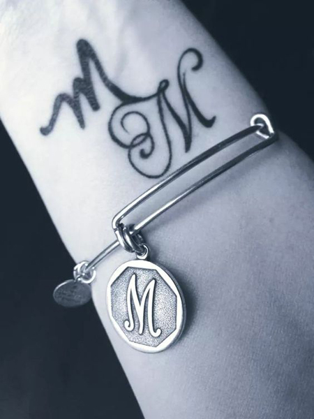 Két betűs M tetoválás a csuklón