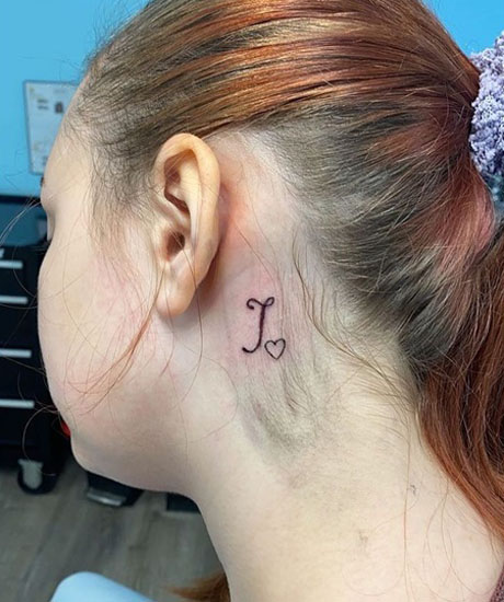 Lenyűgöző J tetoválás a fül mögött