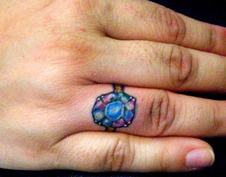 Blå og lilla diamanttatovering på fingeren
