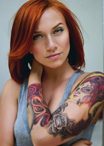 Hevesen kinéző nő teljes ujjú tetoválással