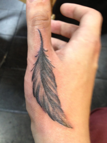 Egy toll tetoválás tervezés a kezében