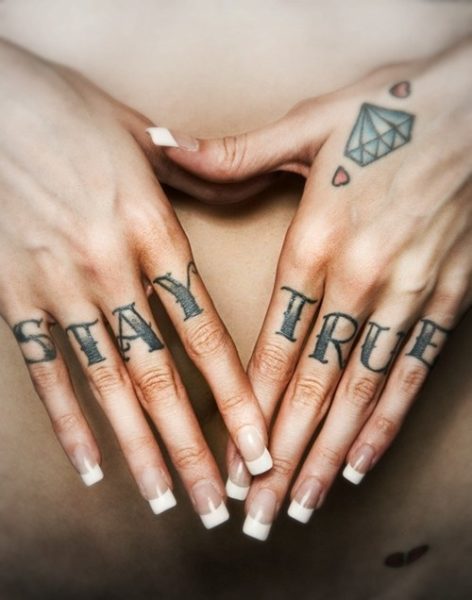 Tetováló szavak az ujjakon