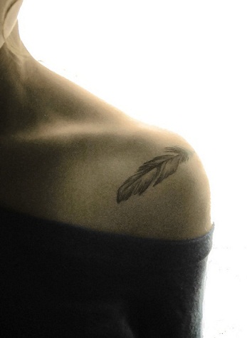 Et lille fjer tatoveringsdesign på skulderen