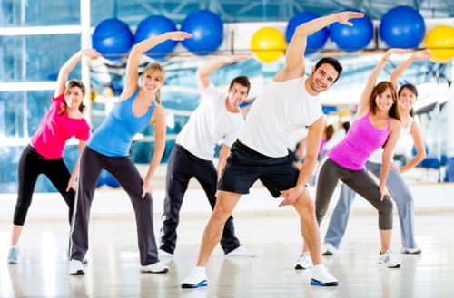 Gruppe af mennesker i gymnastiksalen i en aerobic -klasse