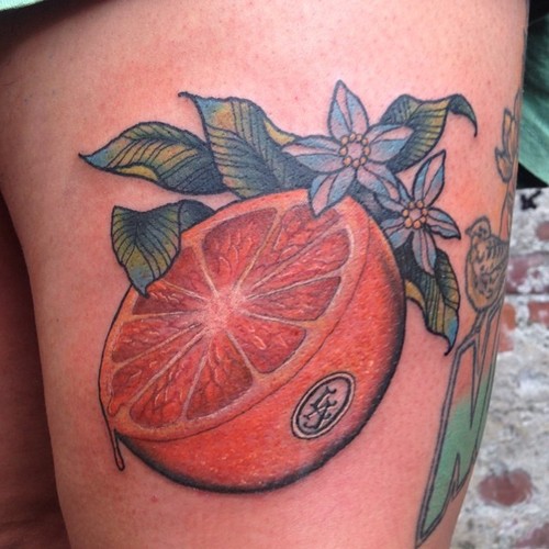 Fél narancssárga zöld levelek tetoválással