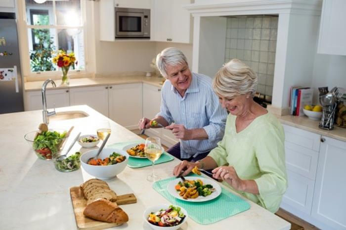 Laihtua vanhuudessa nainen kiinnittää huomiota terveelliseen ja korkeakaloriseen ruokaan syödessään