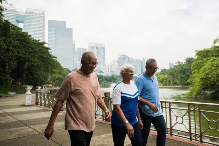 Kolmen ikäiset ystävät laihtuvat kävellessään joen ohi puistossa suuressa kaupungissa