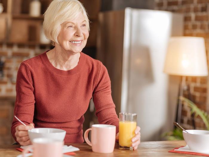 Laihtuminen ikääntynyt vanhempi nainen keittiössä kirjoittaa jotain juomien smoothie -teestä