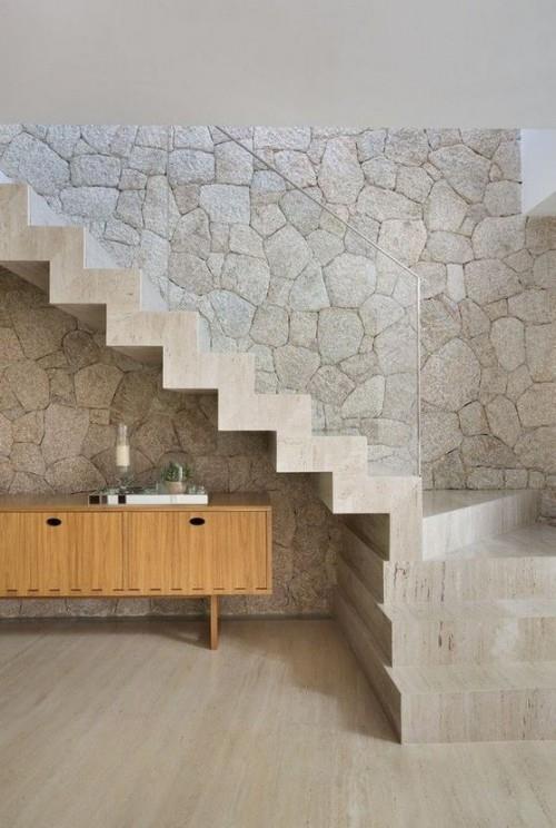 Aksenttiseinä moderni seinäsuunnittelu eteinen kivi lasi puu betoni materiaalien sekoitus