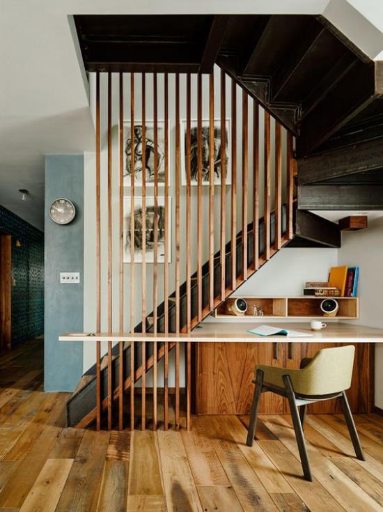 Työalue portaiden alla erittäin tyylikäs muotoilu paljon puuta lämpimiä värejä käytännöllinen työpöytä mukava tuoli