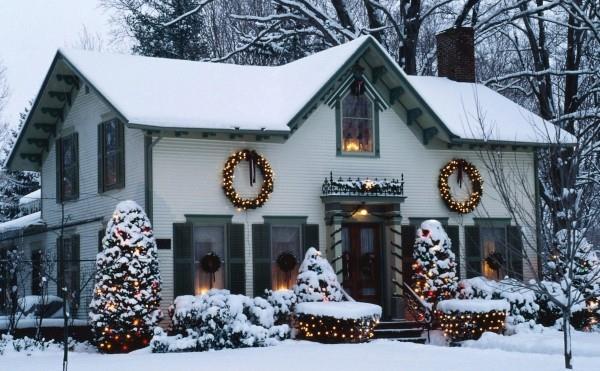 Laita ulkovalaistus jouluksi - 30 juhlaideaa ja vinkkiä valkoinen talo lumen peitossa ja pienet keltaiset valot