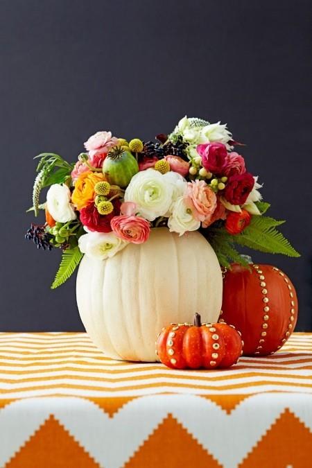 Onteloitu kurpitsat maljakoina täynnä syksyn kukkia Pöydän koristelu syksyllä