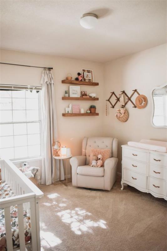 Vauvan huone mukavassa valkoisessa nojatuolissa kulmanvaihtopöydän seinähyllyssä