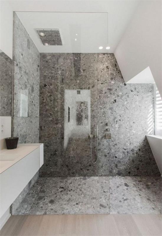 Kylpyhuoneen mallit harmaalla betonilattialla betoniseinällä suihku kulma lasiseinä
