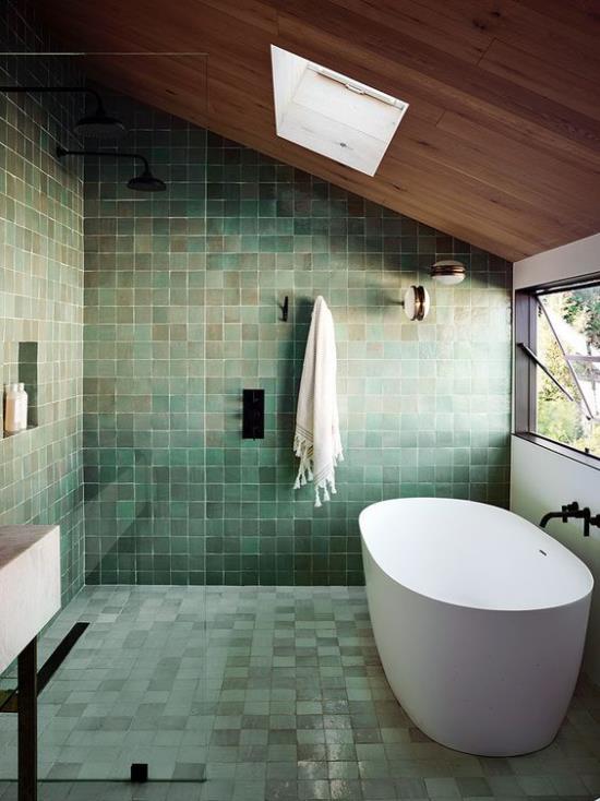 Kylpyhuoneen trendit 2021 vihreät seinä- ja lattialaatat eri sävyjä valkoiset kylpyammeet ikkuna oikea kattoikkuna valon yläpuolella