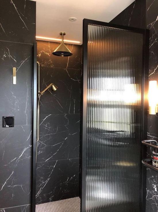 Kylpyhuoneen trendit 2021 tyylikäs kylpyhuoneen muotoilu mustat laatat lasiovi kullankeltainen aksentti tyylikäs ulkonäkö