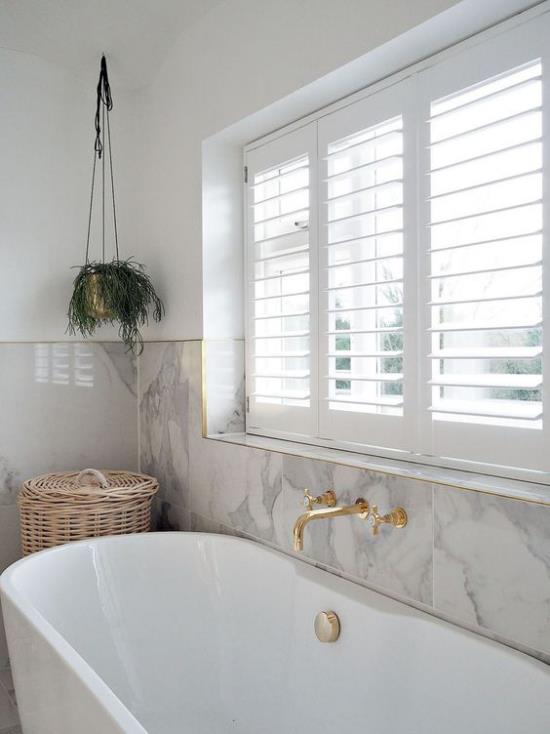 Kylpyhuoneen trendit 2021 valkoinen kylpyamme iso ikkuna valkoinen marmori seinälle