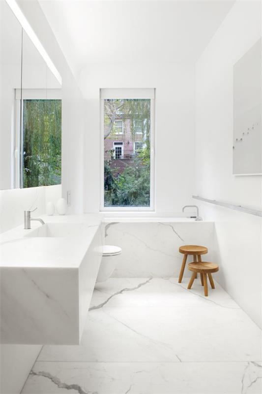Kylpyhuone valkoinen, pienet puiset jakkarat erityisenä katseenvangitsijana, marmorilaatat