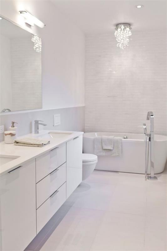 Kylpyhuone kokonaan valkoisessa keinovalaistuksessa peilivalaisin kattovalo pieni kattokruunu katseenvangitsija