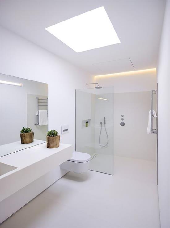 Kylpyhuone kokonaan valkoisessa luonnonvalossa ylhäältä avaruudesta suuret ja kutsuvat kylpyammeet