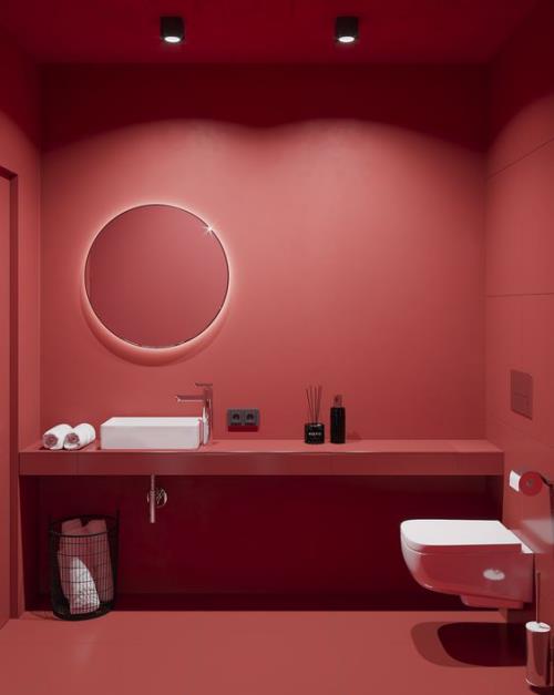 Kylpyhuone punaisessa wc: ssä valkoinen turhamaisuus pesuallas valkoiset pyyhkeet kaikki muu punainen viileä valaistus pyöreä peili