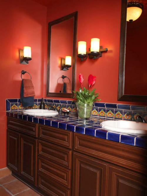 Punaisessa klassisessa kylpyhuoneessa on turhamaisuus, tummat siniset laatat retro -tyyliin, kaksi pyöreää pesuallasta, seinäpeilit, seinävalaisimet