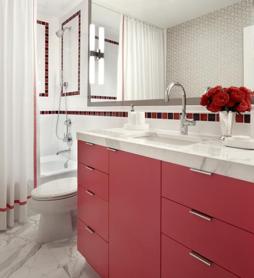 Punaisen klassisen näköinen kylpyhuone, valkoiset kylpyhuonekalusteet, punainen alaosa, suuri seinäpeili, maljakko punaisia ​​kukkia
