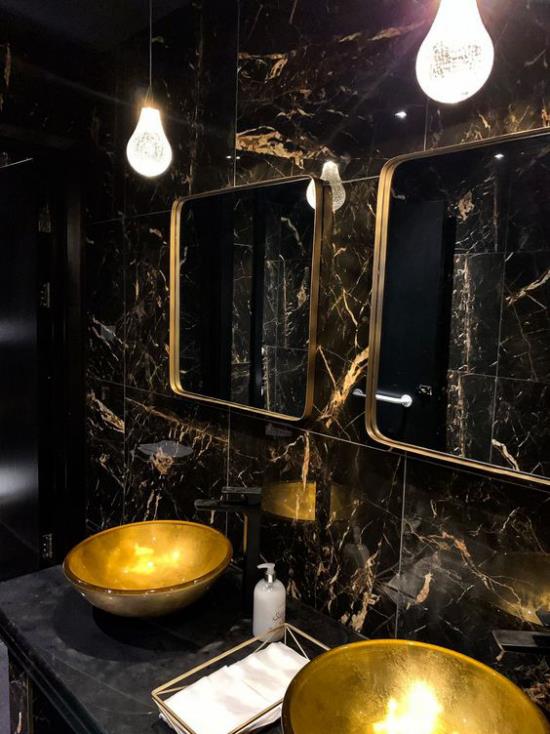 Kylpyhuone musta ja kulta kaksinkertainen turhamaisuus pyöreä pesuallas musta marmori laatat kaksi peiliä kullatut kehykset