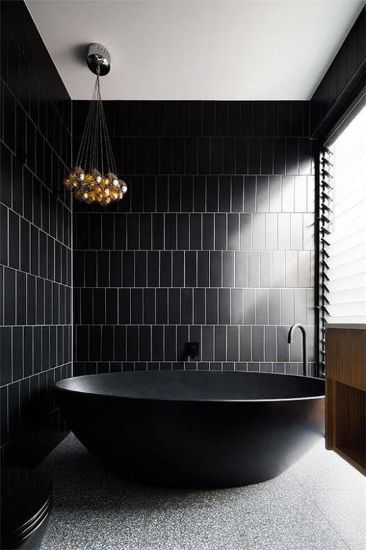 Musta ja kultainen kylpyhuone minimalistiseen tyyliin yksinkertaisuus vapaasti seisovat kylpyammeet harmaa lattia kultaiset kattokruunut