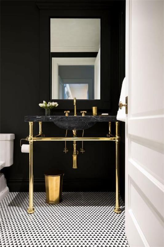 Kylpyhuone musta ja kulta matta musta seinä musta pesuallas kiiltävä kulta elementtejä valkoinen wc