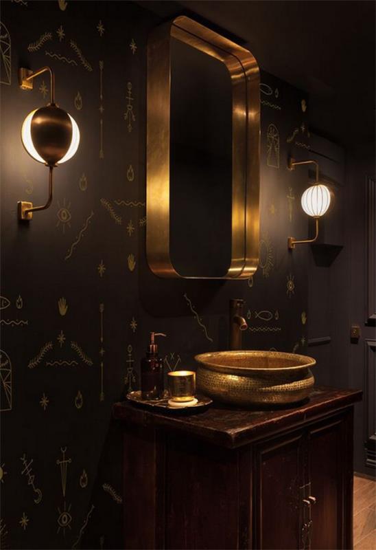 Musta ja kultainen kylpyhuone valaisee modernit seinävalaisimet peilin kummallakin puolella