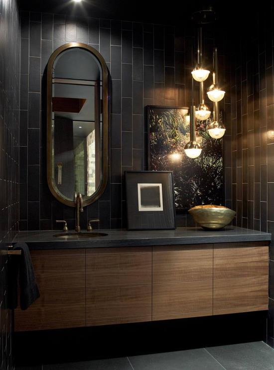 Musta ja kultainen kylpyhuone eri valonlähteissä yhdistää riippuvalaisimen sisäänrakennetun huonevalon