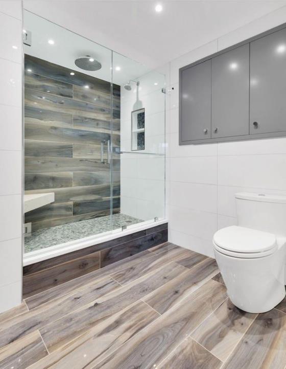 Kylpyhuoneen laatat puuta, iso kylpyhuone, wc, suihkukaappi, lasiseinä, kaikki kaakeloitu