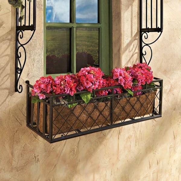 Kukkalaatikko metallilaatikon ikkunalaudalla monet punaiset kasvit vähän vihreitä