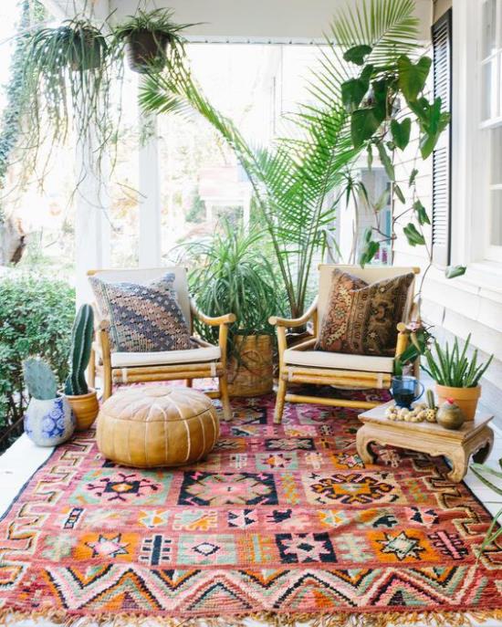 Boho -tyylinen kuisti vanha nojatuoli jakkara värikäs matto